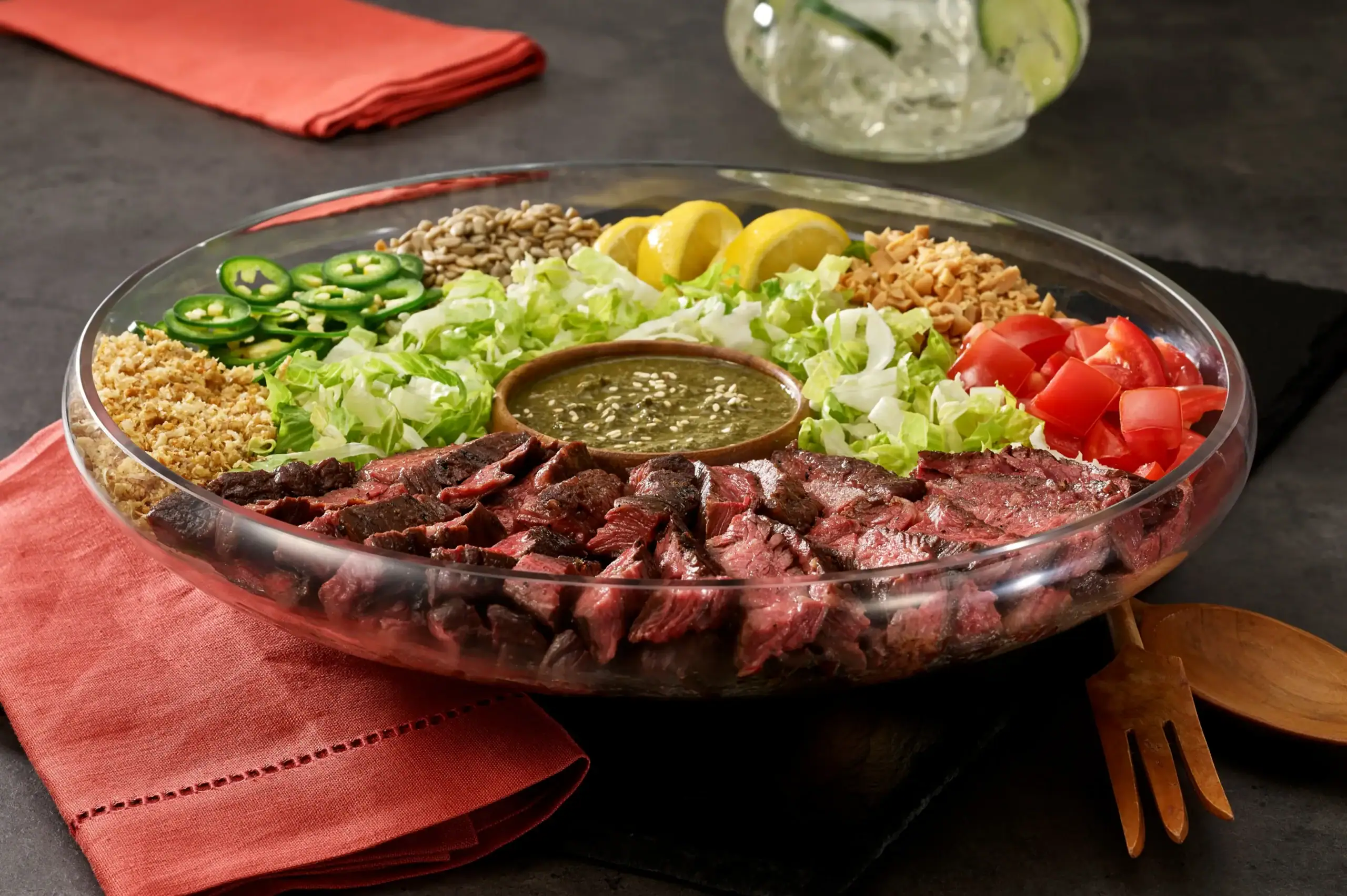 Composed platter of sliced Imperial American Wagyu steak with jalapeno, tomato, lettuce and chimichurri