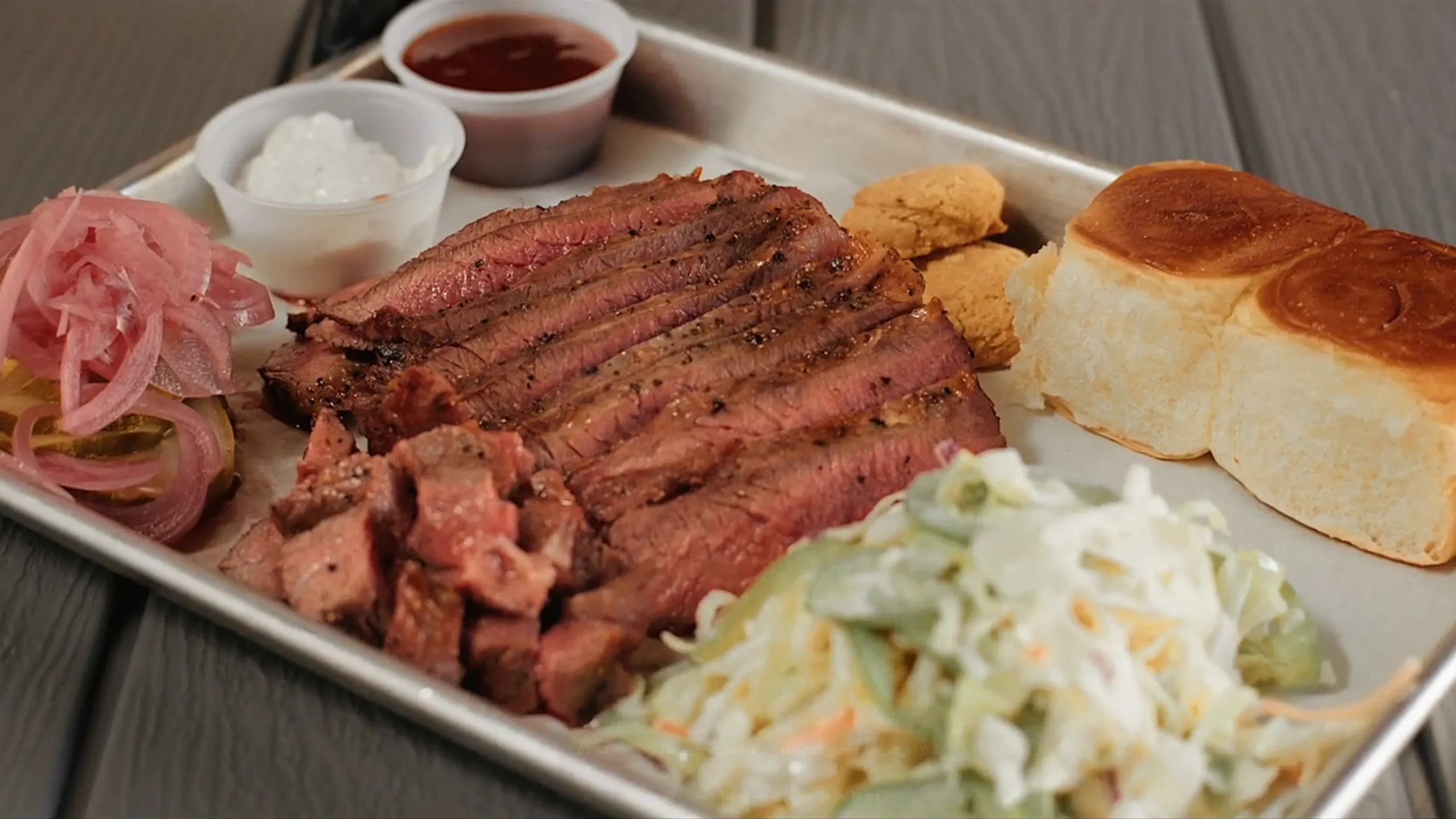 Santa Maria-style Wagyu tri-tip, served with slaw, pickled onions, and dinner rolls